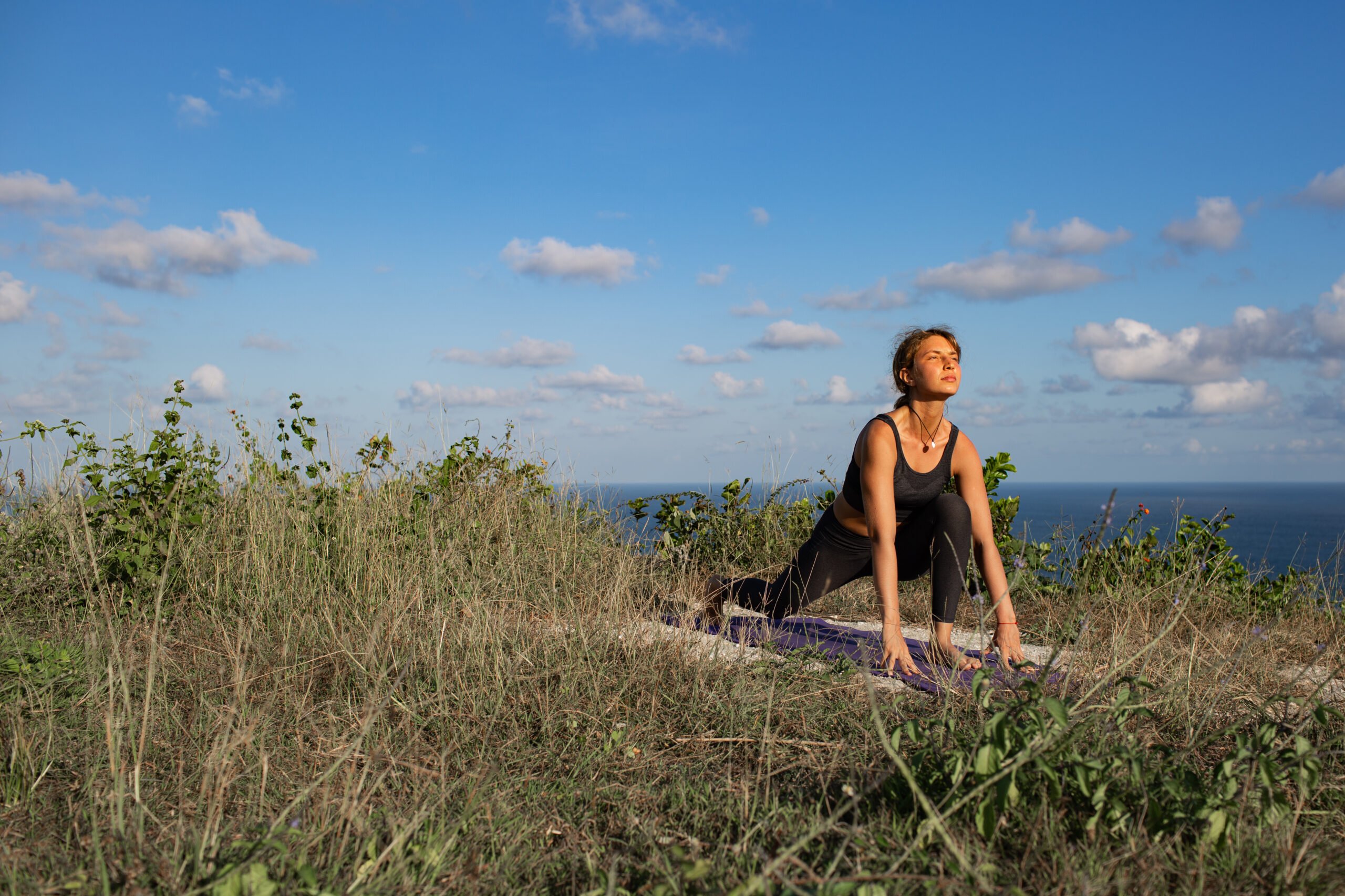 Young woman doing yoga outdoors with amazing back view. Bali. Indonesia.